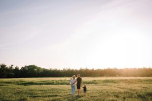 A family is walking towards the horizon