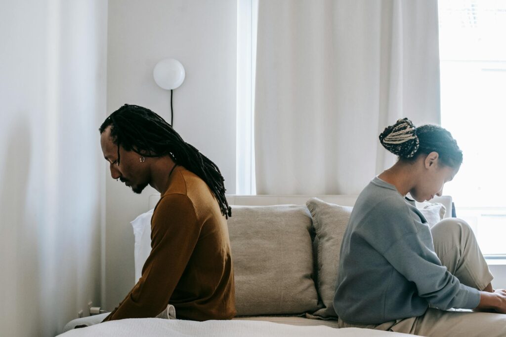 Couple sitting apart experiencing the pursue-withdraw pattern in their relationship