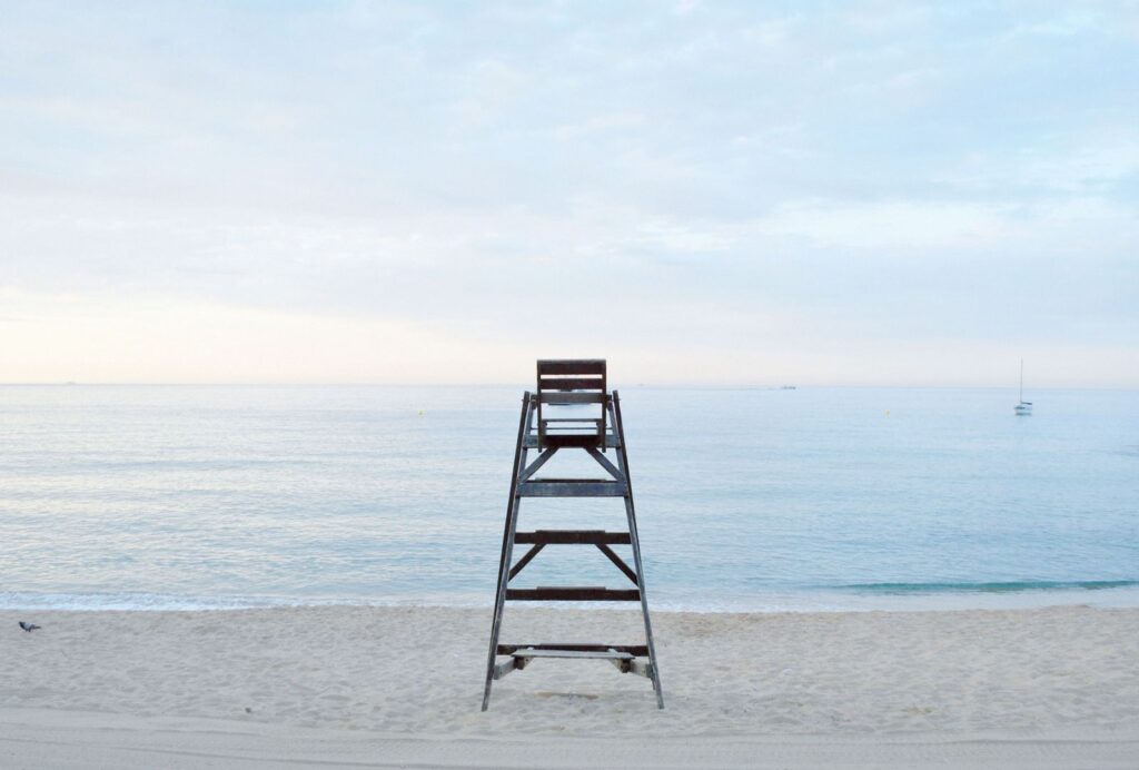 Lone metal step ladder on an empty beach — summer depression and solitude in sunshine